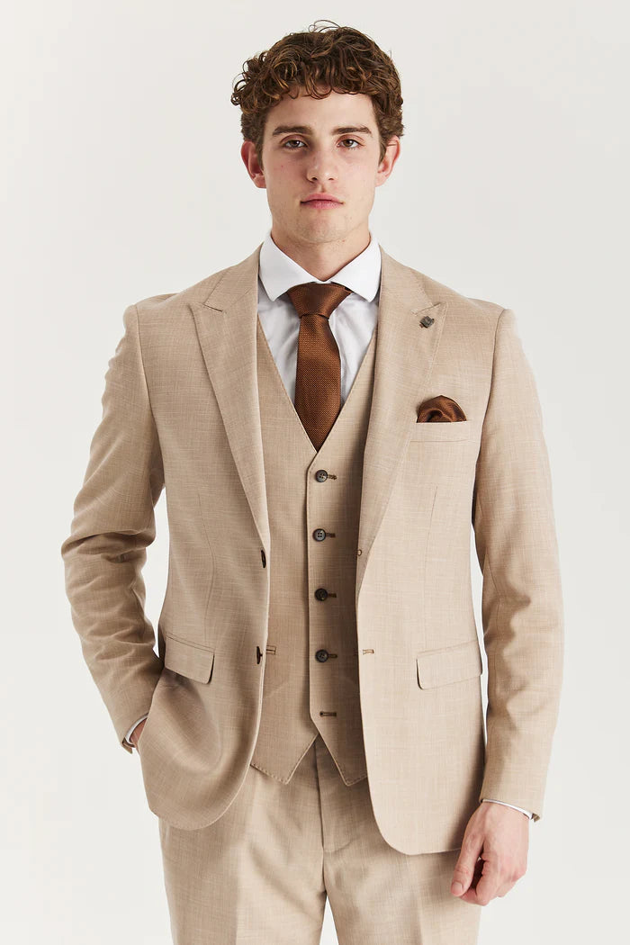 Close-up of a man wearing a beige three-piece suit with a brown tie and pocket square, showcasing the jacket and waistcoat.