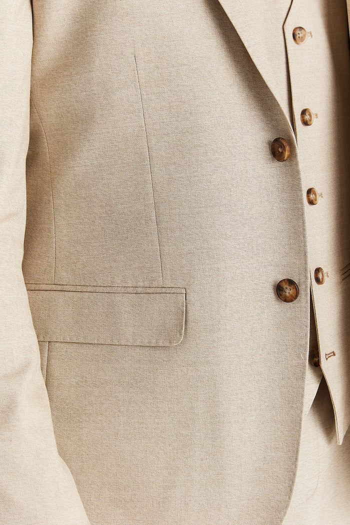 Close-up detail of blazer pocket and brown button texture on the Belmont Beige suit.