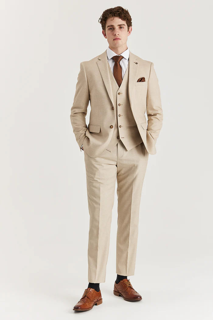 Full body view of Paul Andrew Belmont Beige suit worn with brown brogues and hands in pockets.