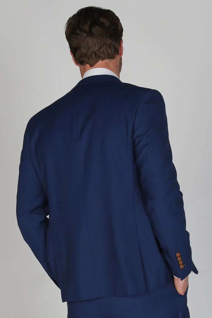 Back view of the blue blazer highlighting clean stitching, classic structure, and brown button cuff accents.
