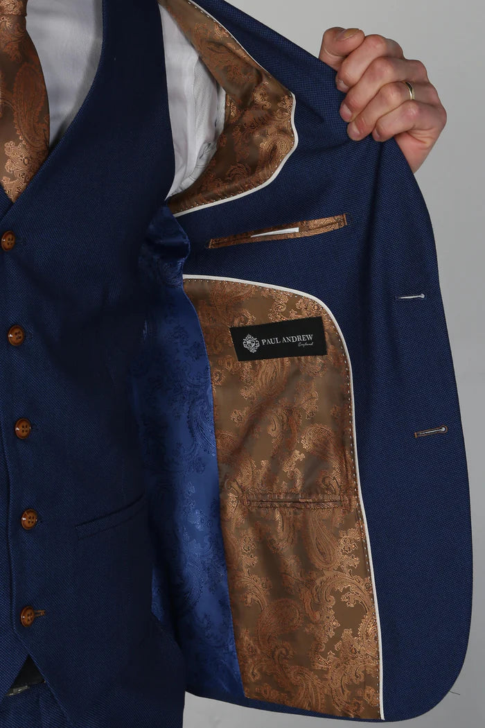 Inside view of the blue suit jacket showcasing goldish brown paisley and blue satin lining with Paul Andrew branding.