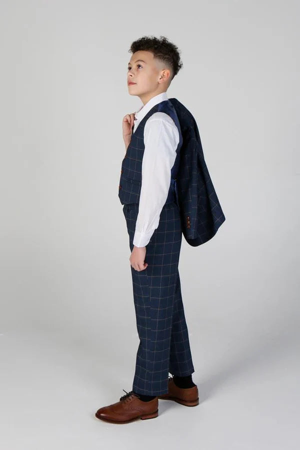 Back view of young boy in navy windowpane suit, showing tapered cut and adjustable waistcoat strap detail.
