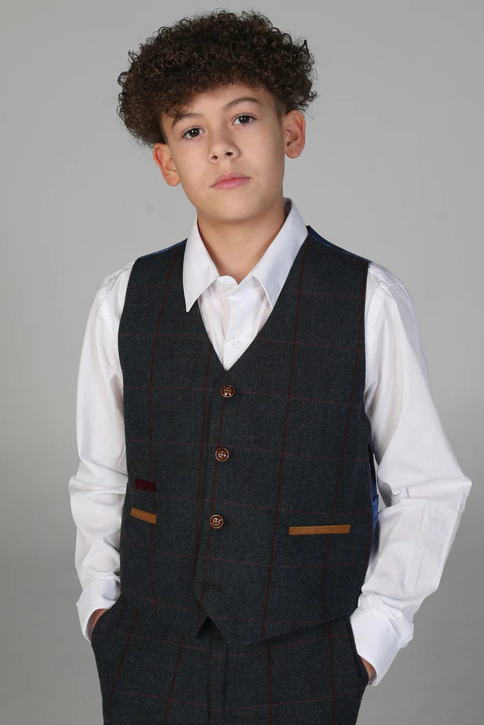 Boy in matching navy check waistcoat with multicolored pocket trim and brown buttons, worn over a white shirt.