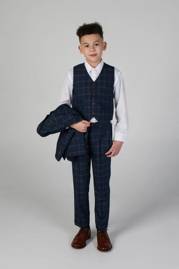Boy in navy windowpane waistcoat and trousers holding matching suit jacket, showcasing versatility of three-piece formal outfit.