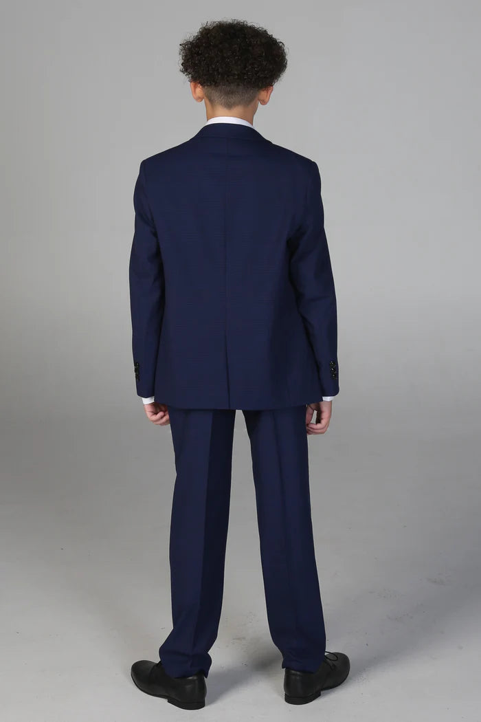 Rear view of navy three-piece suit on boy, displaying tailored jacket and straight-leg trousers.