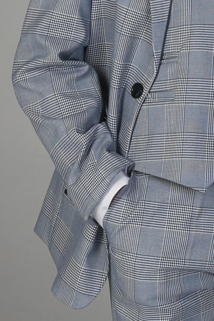 Close-up of light blue grey check suit jacket with black button and fine grid pattern.