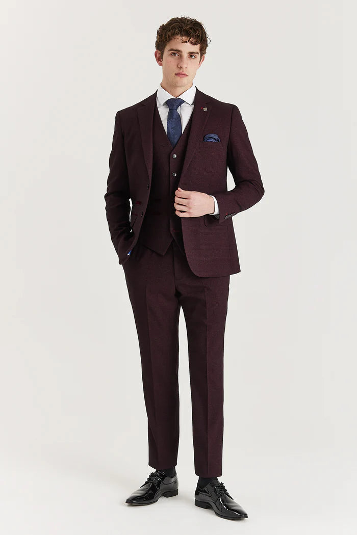 Full front view of a man wearing a burgundy check three-piece suit with a white shirt and navy tie.
