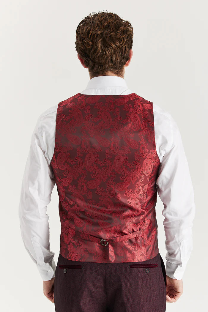 Rear view of a men's burgundy waistcoat featuring a rich red paisley satin pattern and adjustable strap, styled over a white dress shirt.