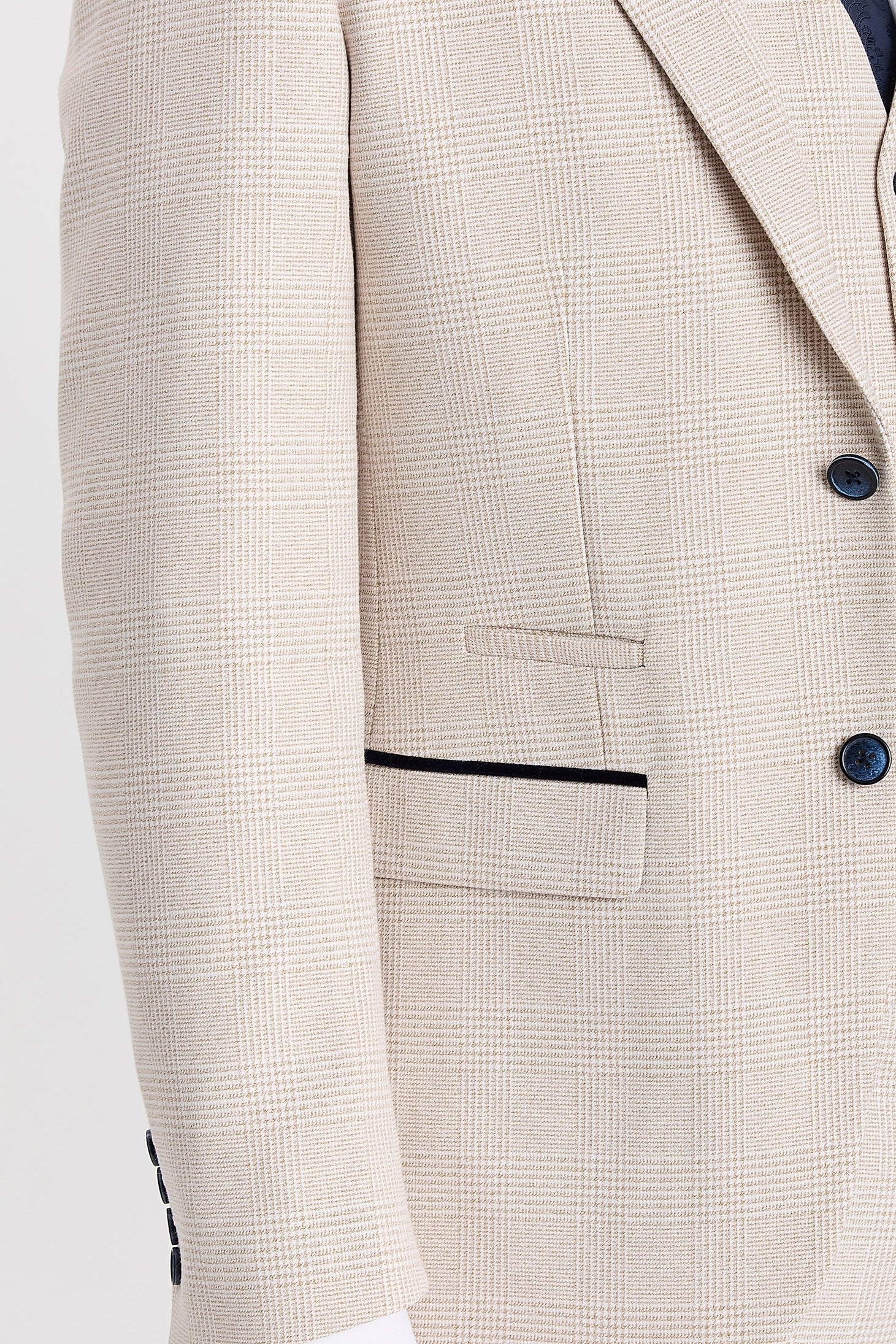 Close-up view of the cream glen check blazer showing the fine woven check, front flap pocket, upper pocket detail, dark suede trim and dark navy buttons.
