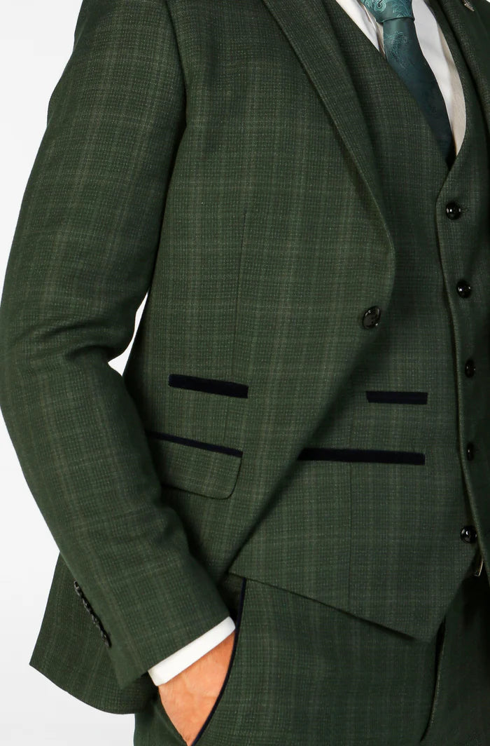 Close-up of green check blazer and waistcoat pockets with dark trim, showing detailed texture and craftsmanship.