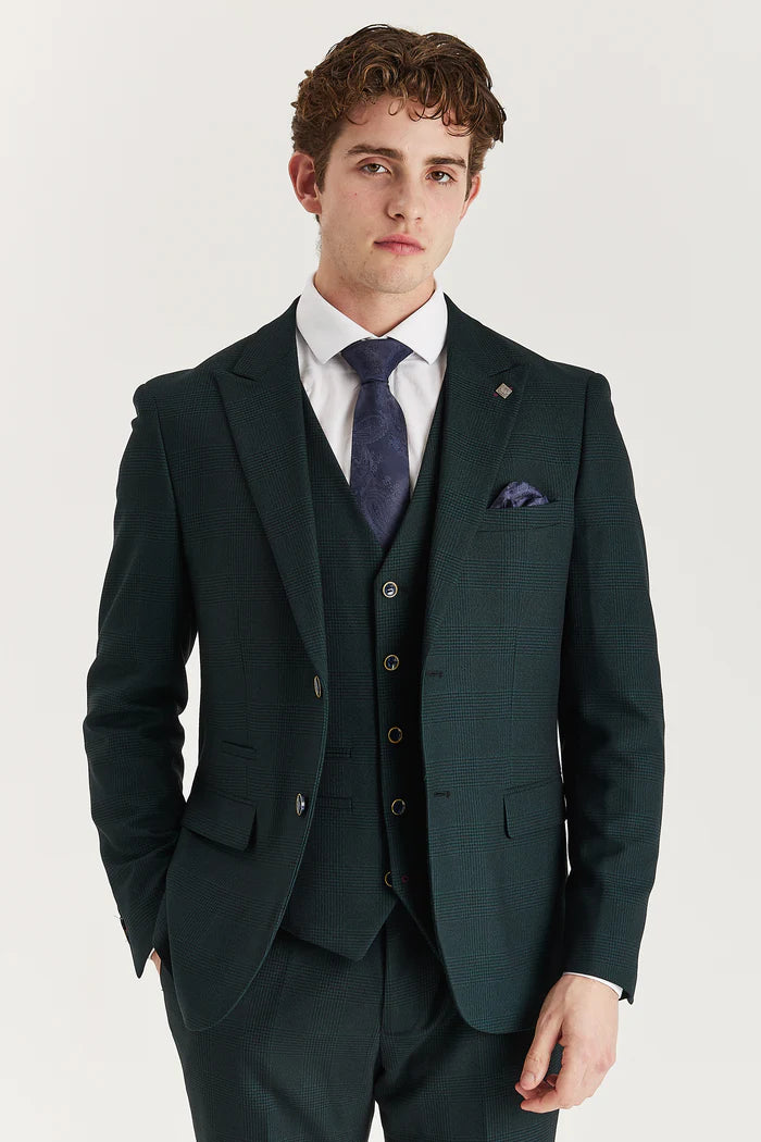 Model in a green check three-piece suit with a navy tie and pocket square, close-up showing the jacket and waistcoat.