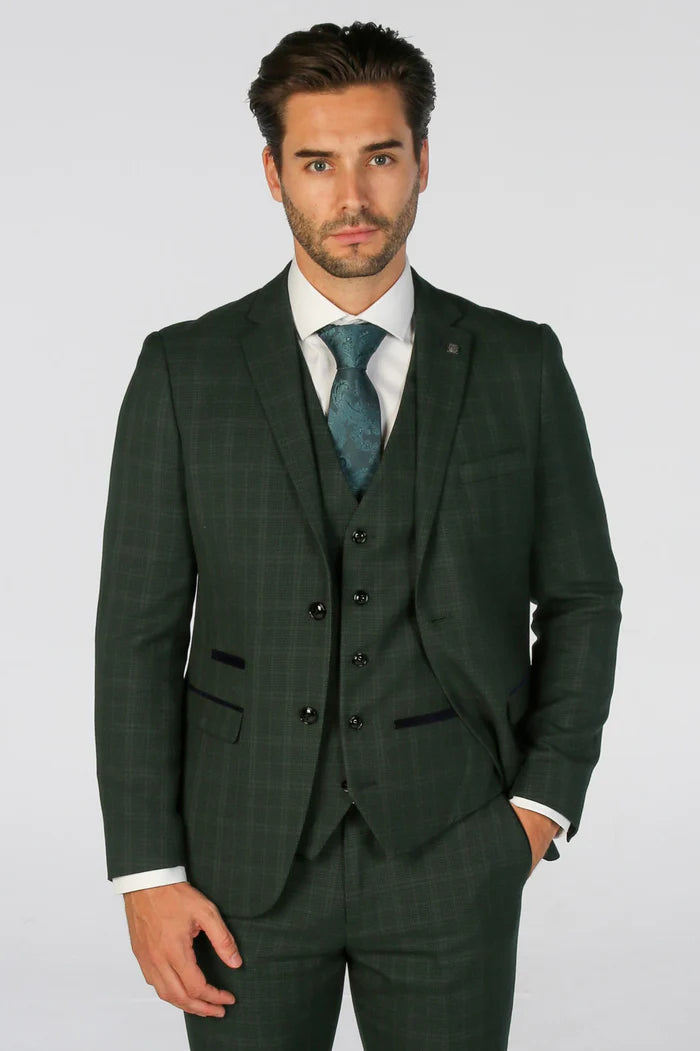 Close-up of a man wearing a green check three-piece suit with teal tie and white shirt, showcasing sharp tailoring.