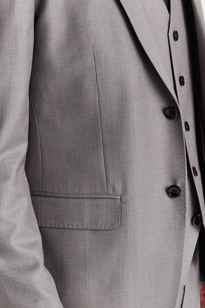 Close-up of the blazer's front pocket and fabric texture in light grey with sleek minimalist stitching.