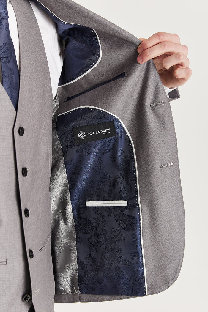 Interior view of the grey suit jacket featuring navy and silver paisley lining with Paul Andrew branding.