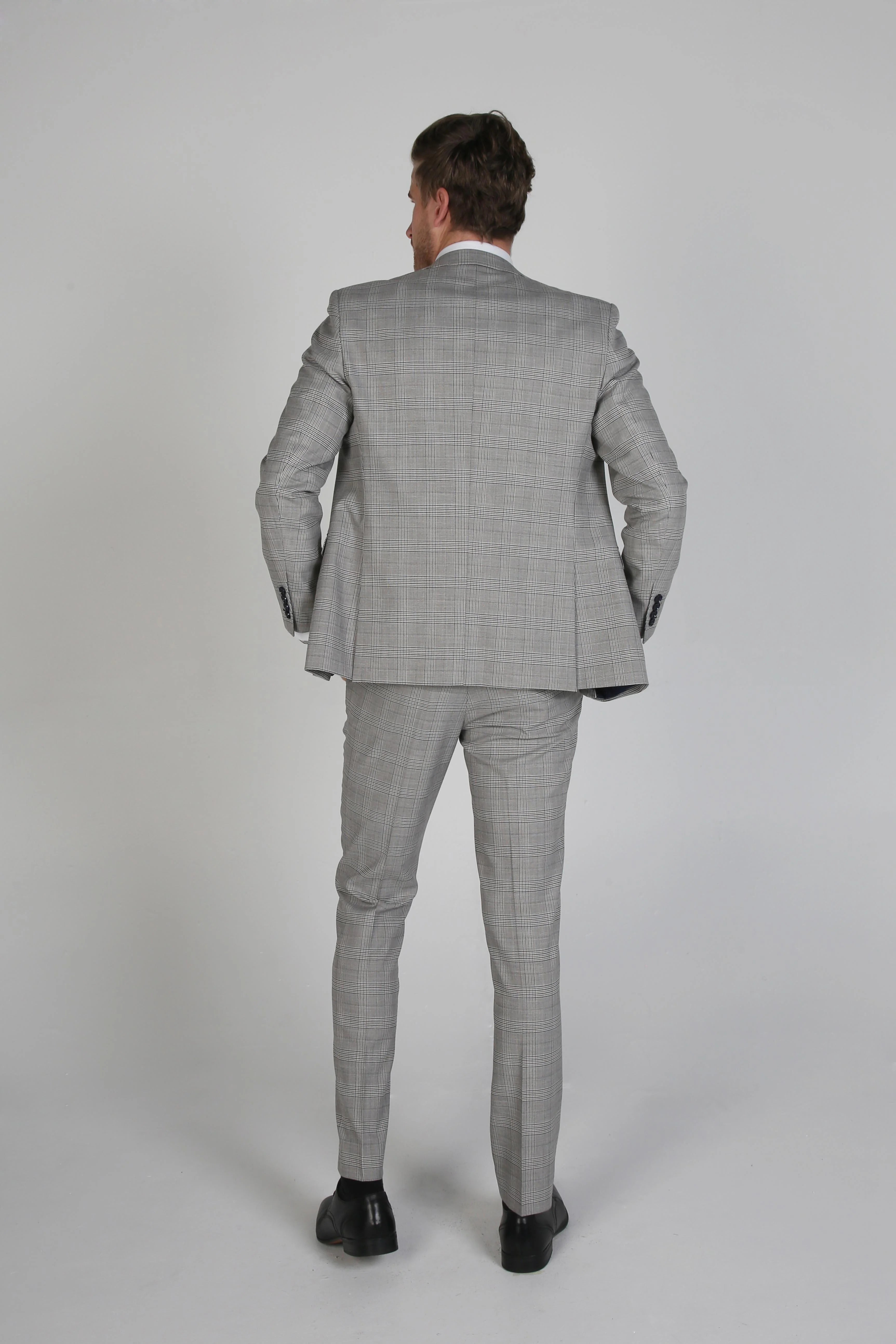 Back view of a man wearing a Hugo grey checkered three-piece suit.