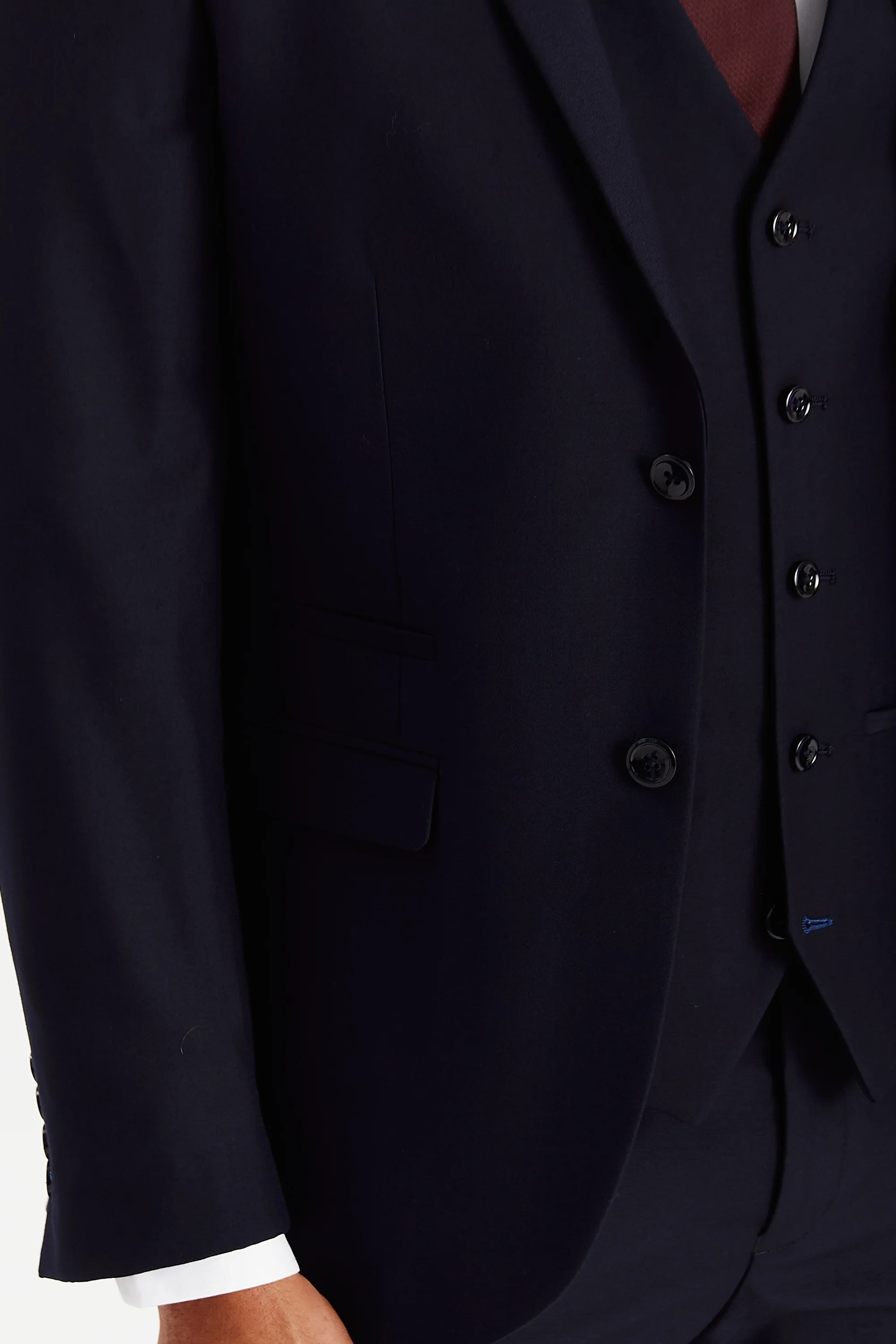 Close-up view of the navy blazer showing the smooth surface, front flap pocket, upper pocket opening and dark buttons.