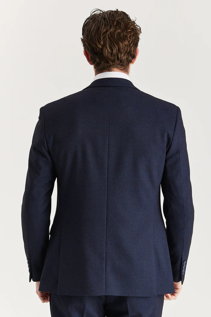 Back view of the navy suit jacket highlighting clean seams, smooth structure, and precision tailoring.