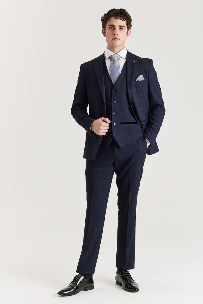Full view of a tailored navy check suit worn with a white shirt, silver paisley tie, and polished black shoes for a sharp formal finish.