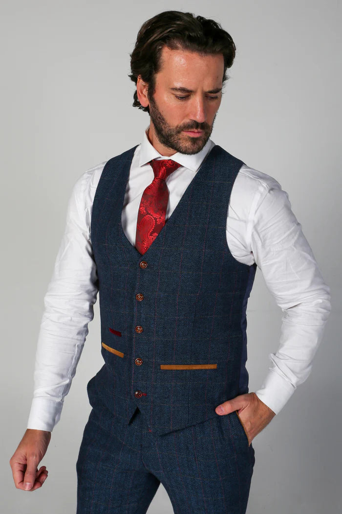 Man wearing the navy tweed waistcoat with white shirt and red tie, showcasing front detail and pocket stitching.