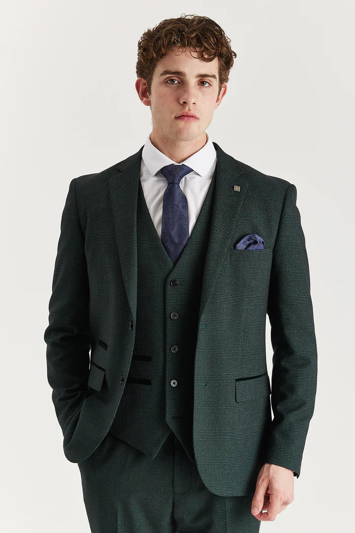 Close-up of a man wearing an olive green check three-piece suit with a navy tie and matching pocket square.