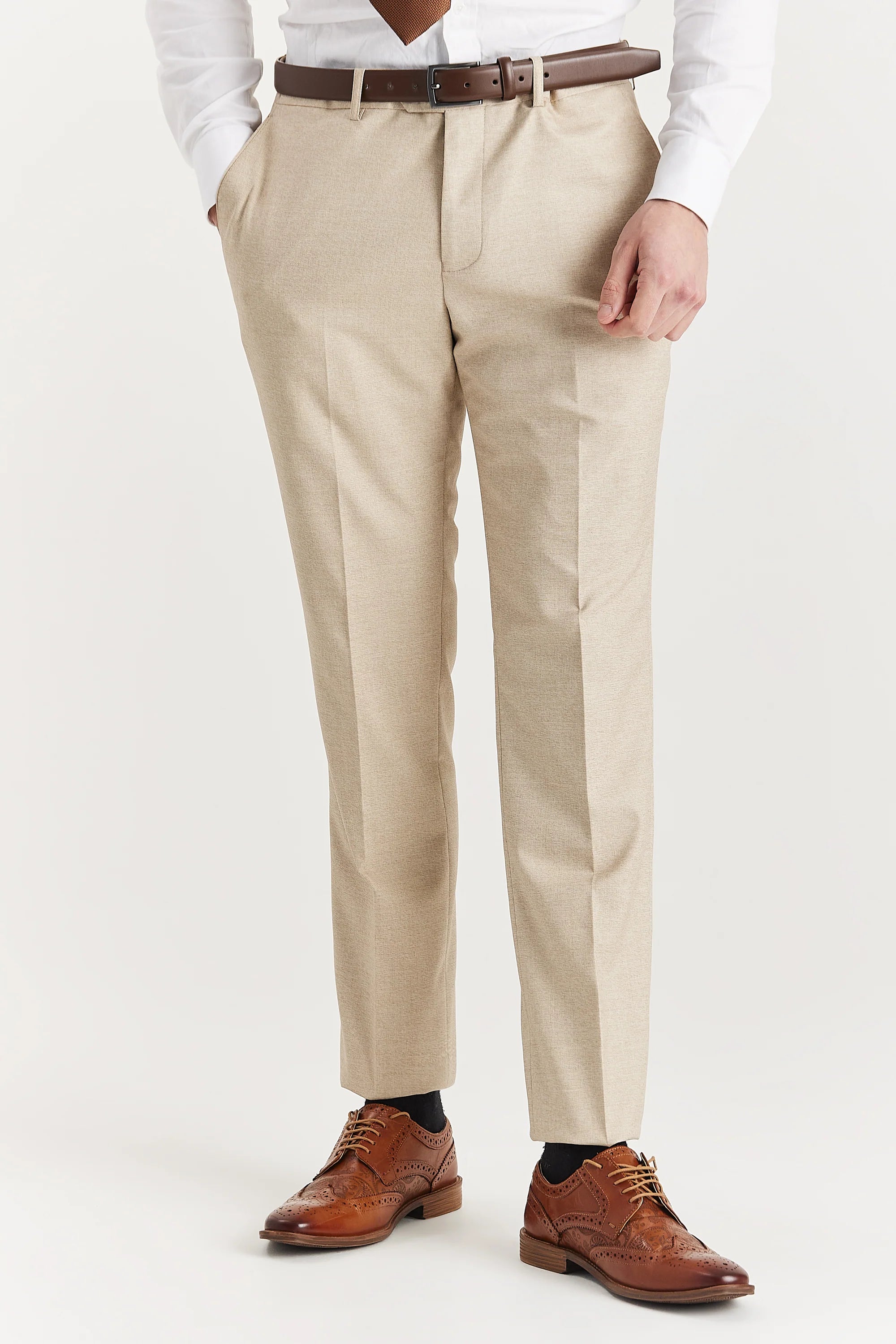 Men’s beige trousers shown from the front, worn with a white shirt, brown tie, brown belt and brown brogues.