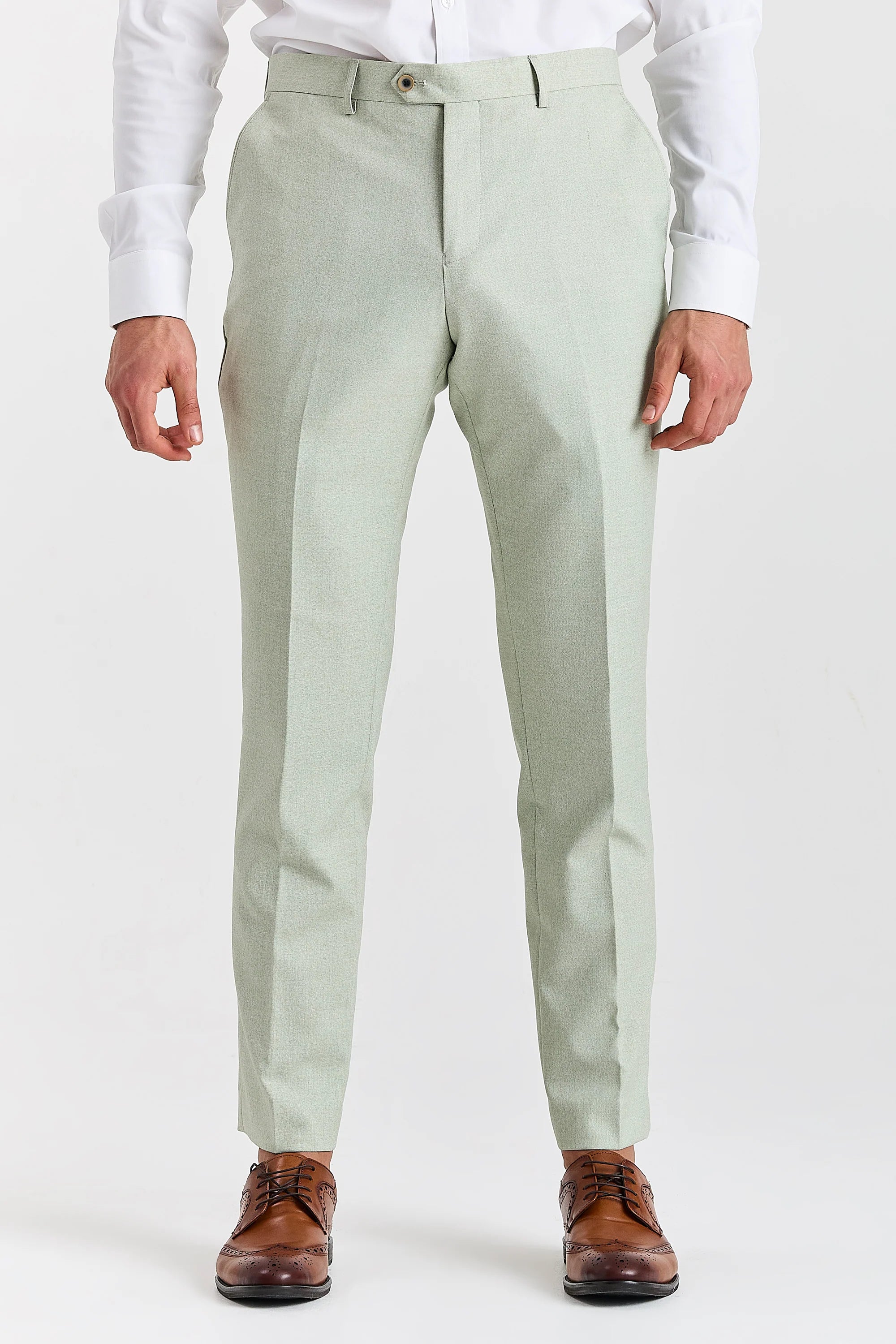 Men’s sage trousers shown from the front, worn with a white shirt and brown brogues.