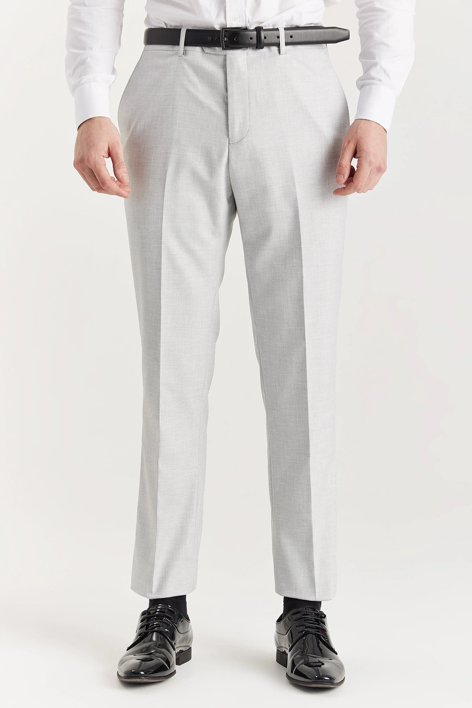Close-up front view of men's tailored silver suit trousers, styled with a black leather belt and shiny black dress shoes.