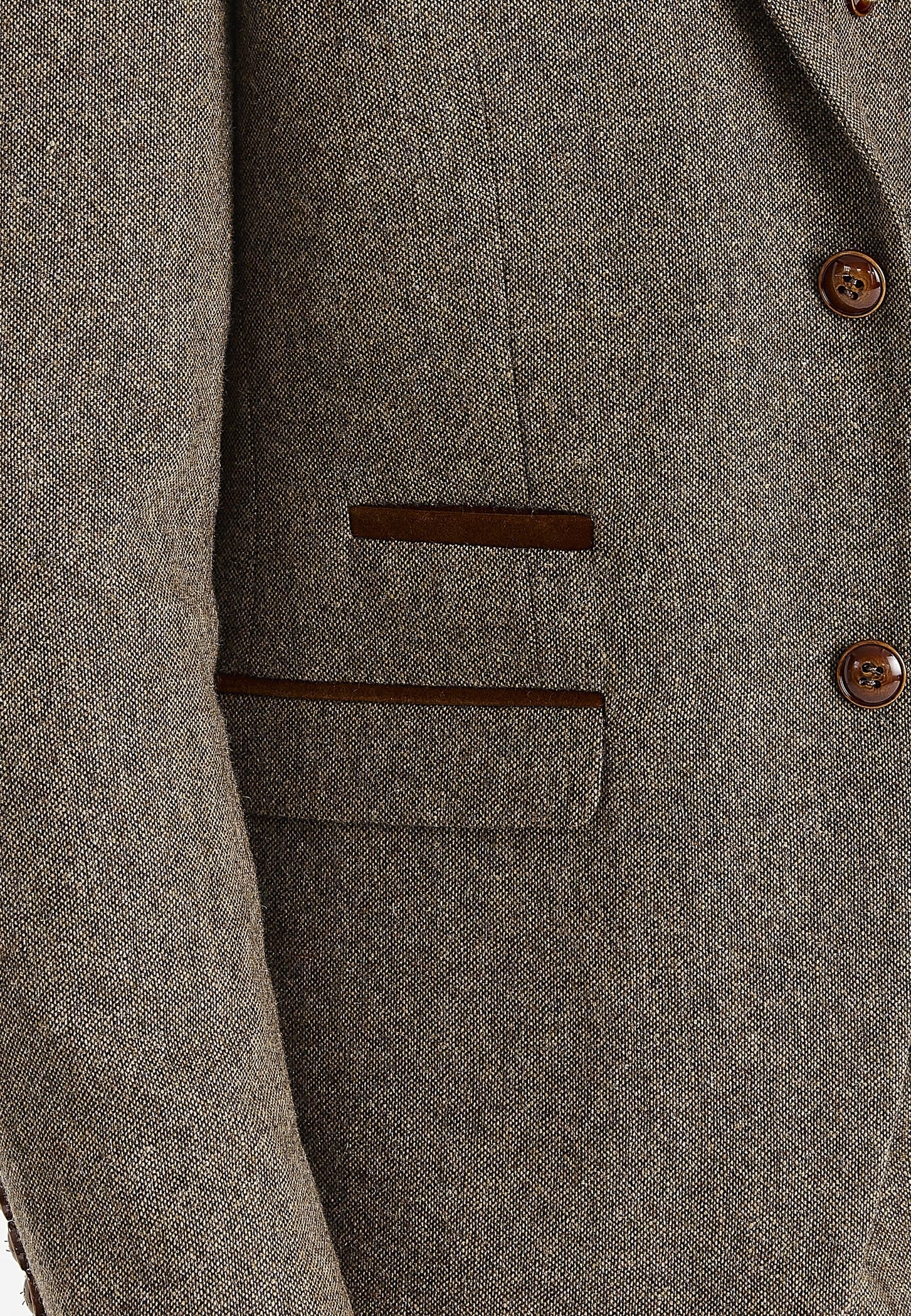 Close-up view of the brown tweed blazer showing the textured woven surface, brown buttons, a front flap pocket and brown suede trim details.