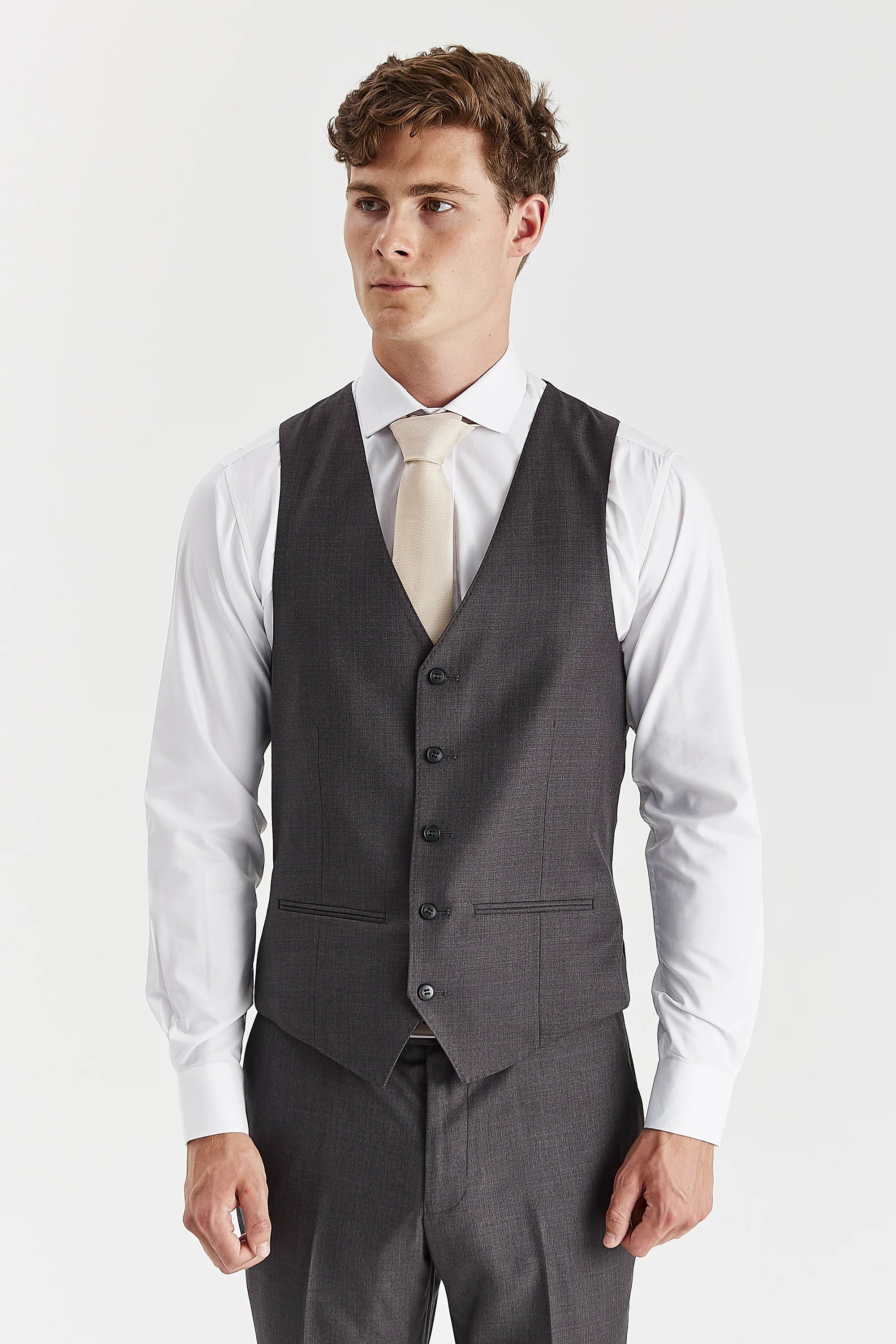 Front view of the charcoal waistcoat, worn with matching trousers, a white shirt and a cream tie.