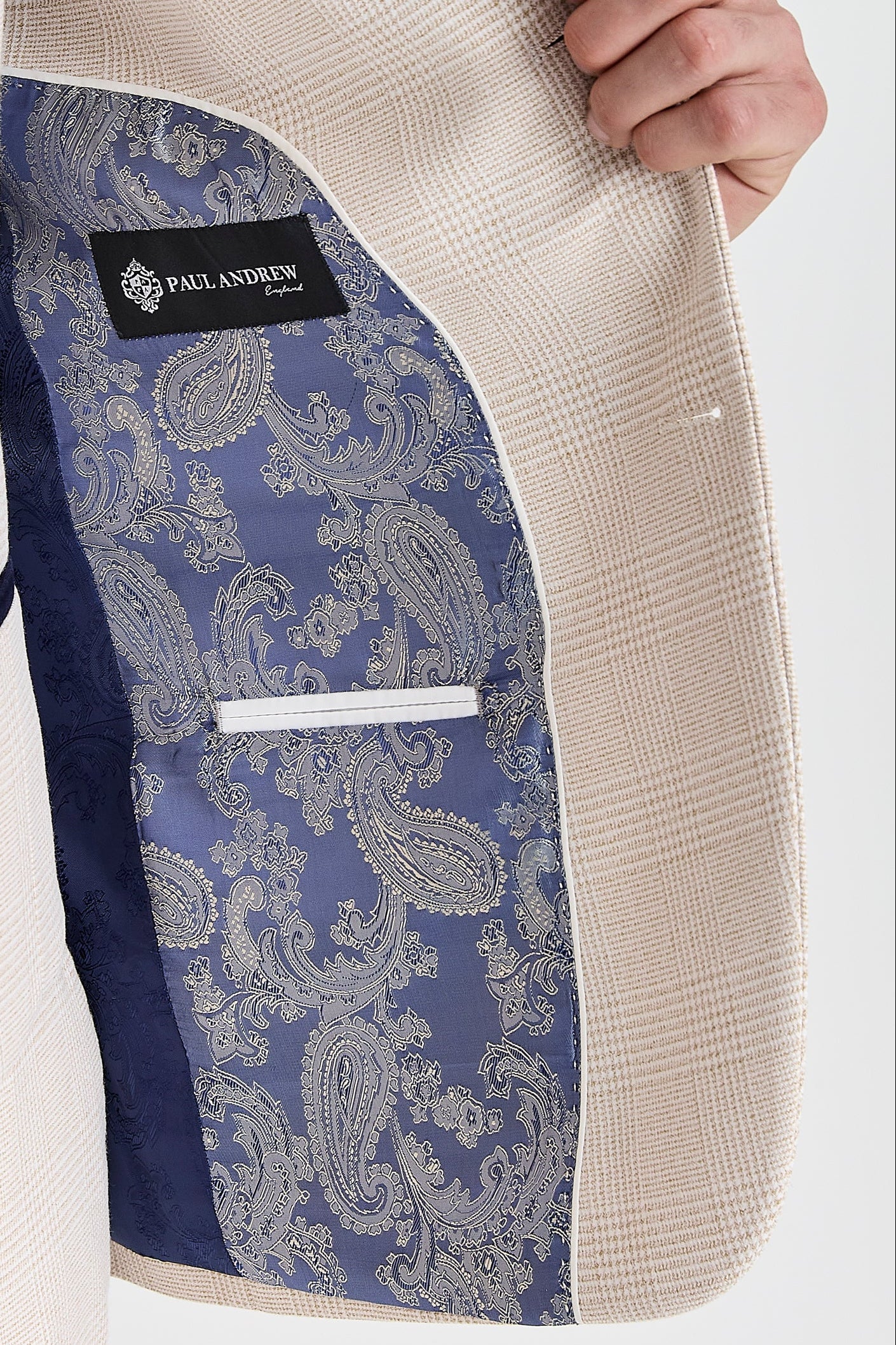 Interior view of the cream check blazer with blue and silver paisley lining and a visible Paul Andrew logo label.