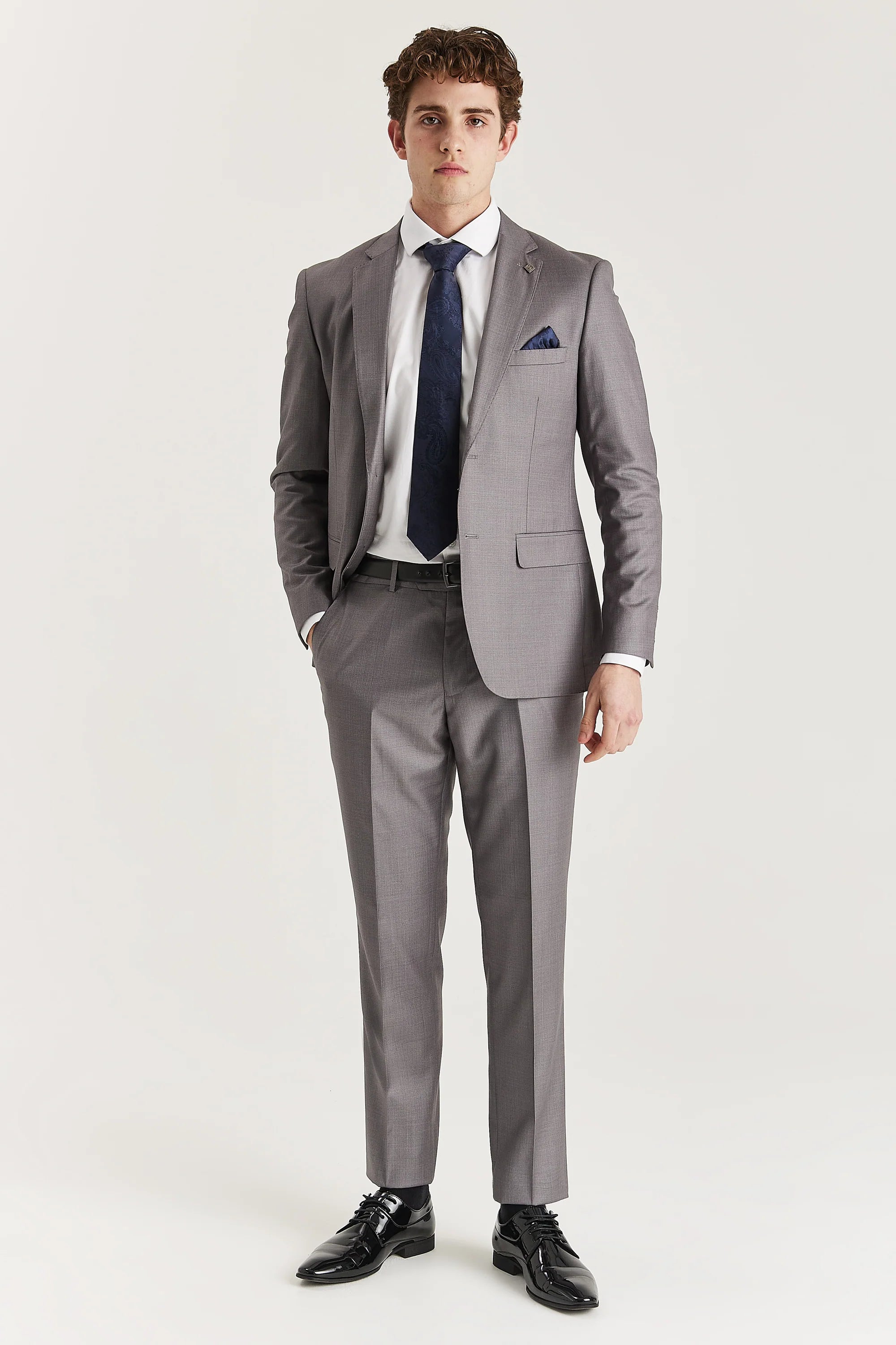Men’s grey trousers shown as part of a full outfit with the matching blazer, white shirt and blue tie.