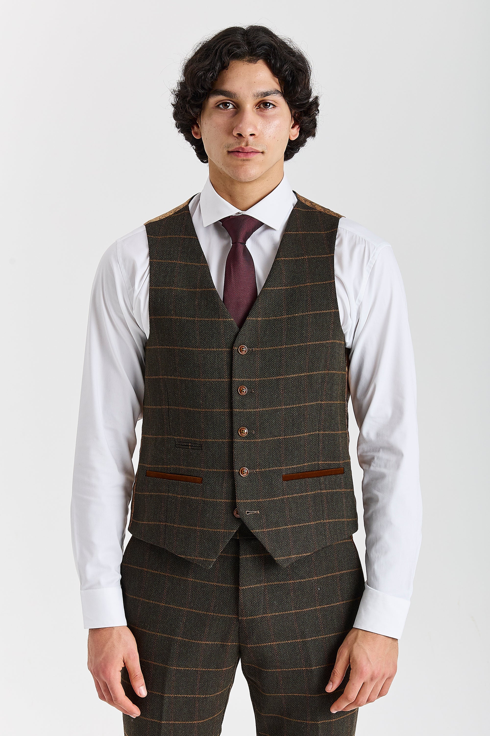 Front view of a Harris green herringbone tweed waistcoat with a tan windowpane check, brown buttons, white shirt and burgundy tie.