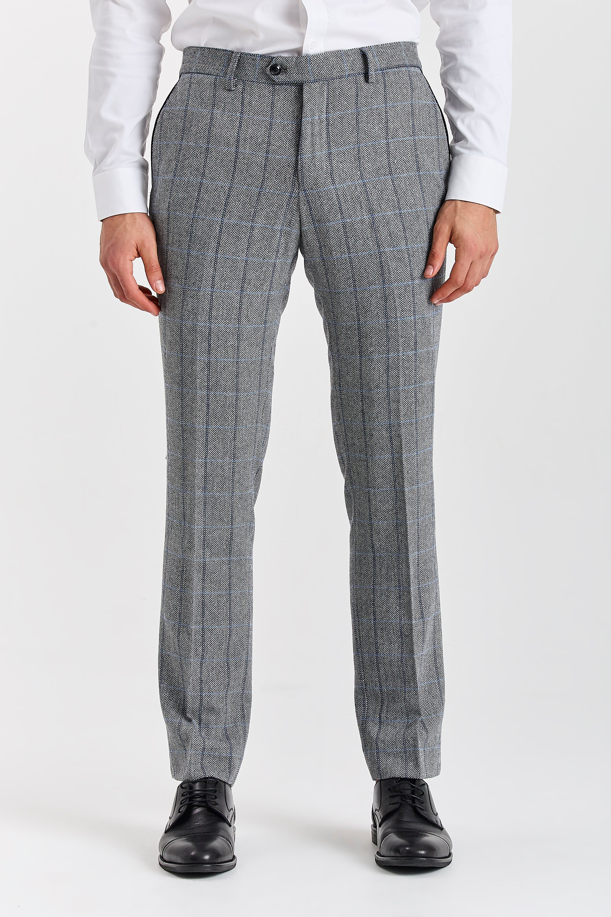 Men’s grey herringbone check tweed trousers shown from the front, worn with a white shirt and black formal shoes.