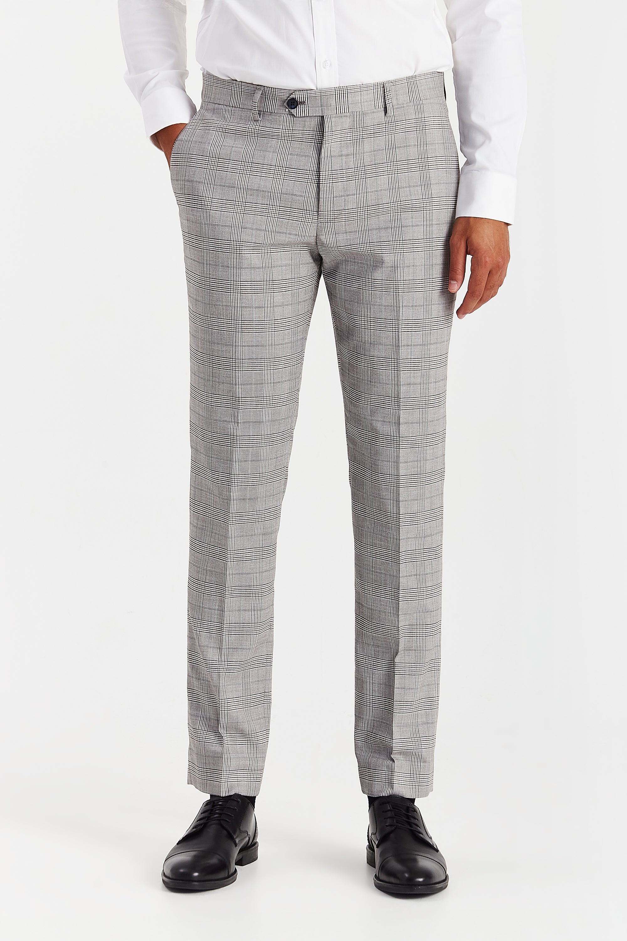 Front view of grey trousers with a glen check pattern, shown with a white shirt and black shoes.