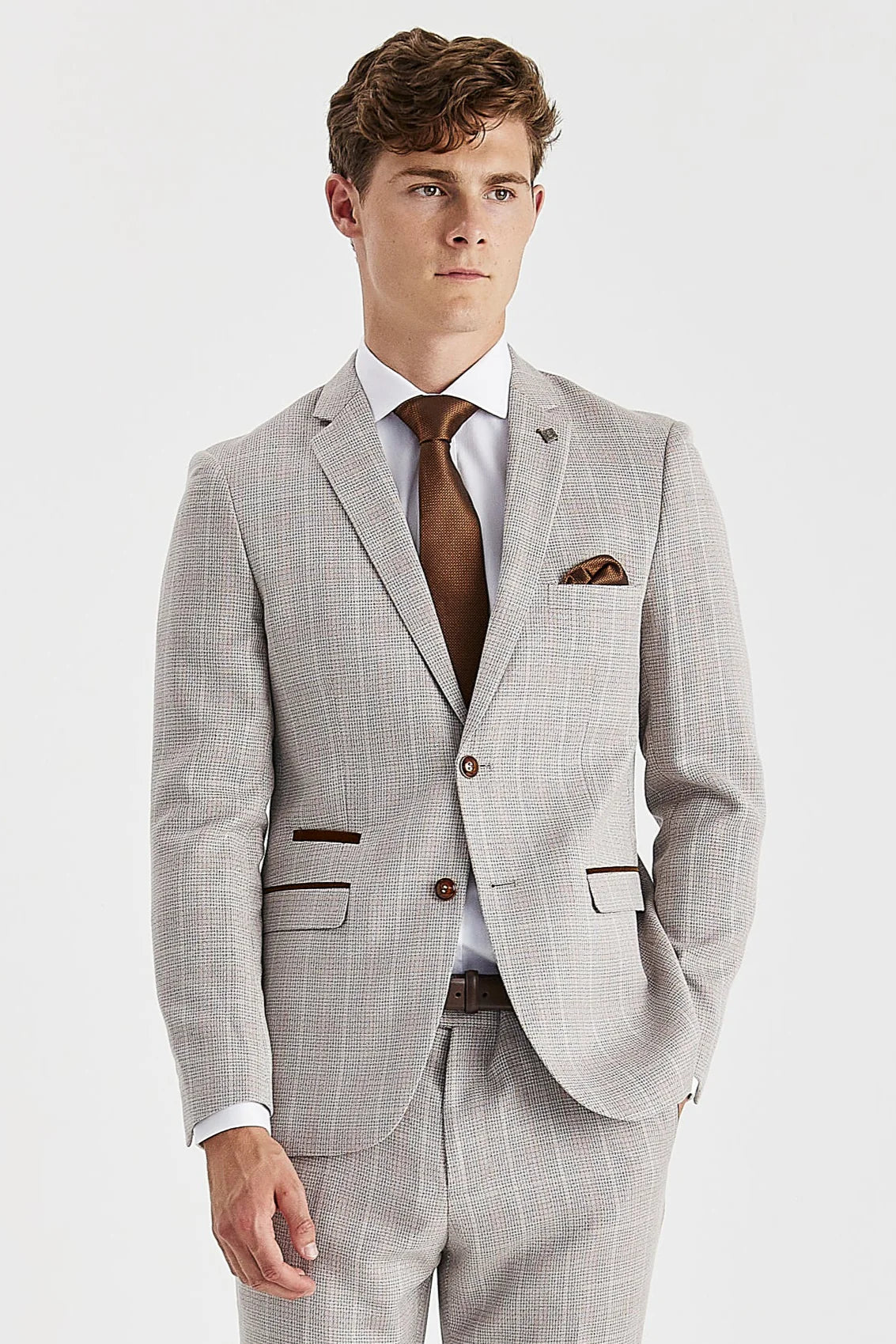 Knee-up view of a man wearing a beige checked suit blazer and trousers , featuring suede trimmings and a white shirt