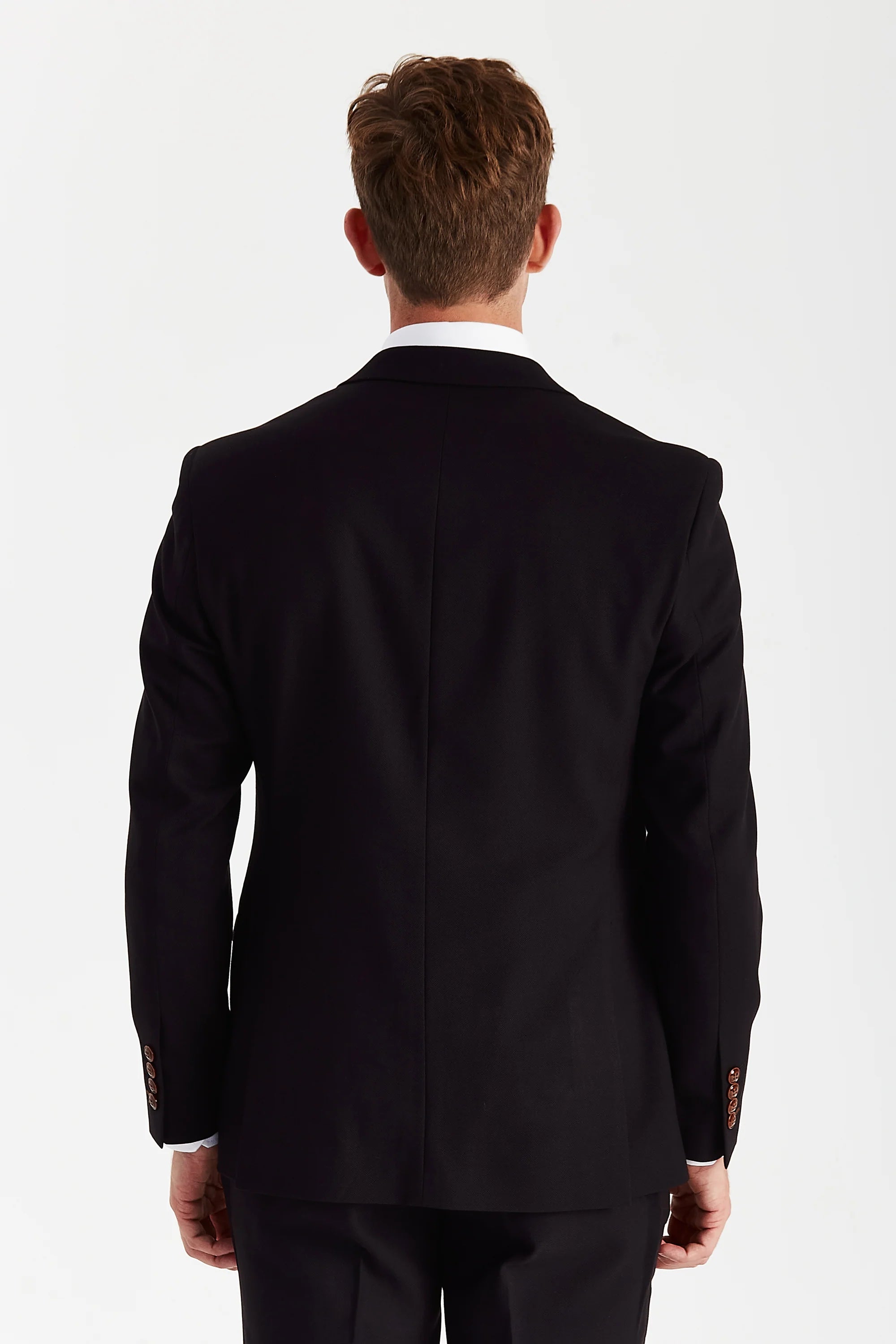 Back view of a black textured suit jacket with matching trousers and brown sleeve buttons.