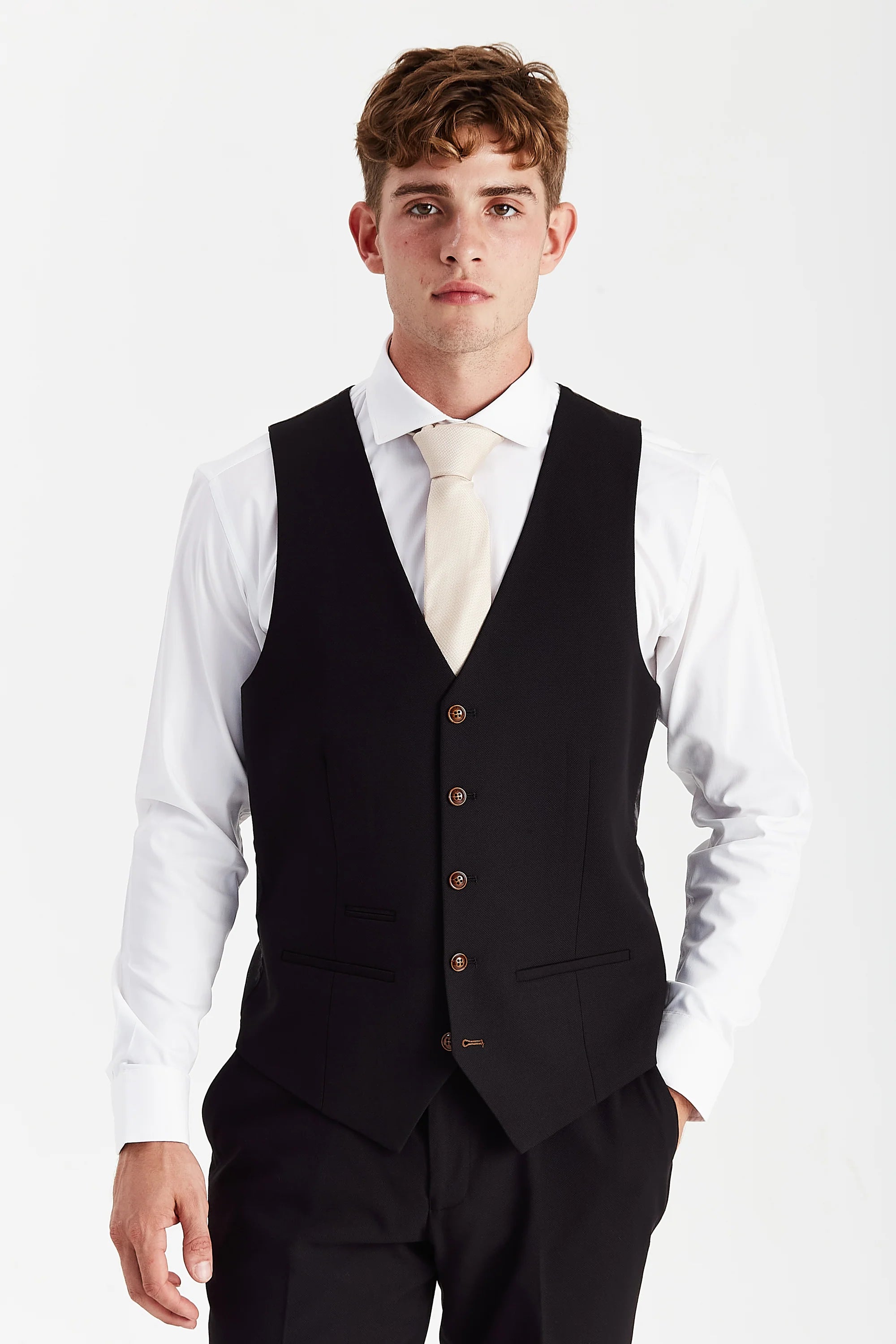 Front view of a black textured waistcoat with brown buttons, matching trousers, white shirt and cream tie.