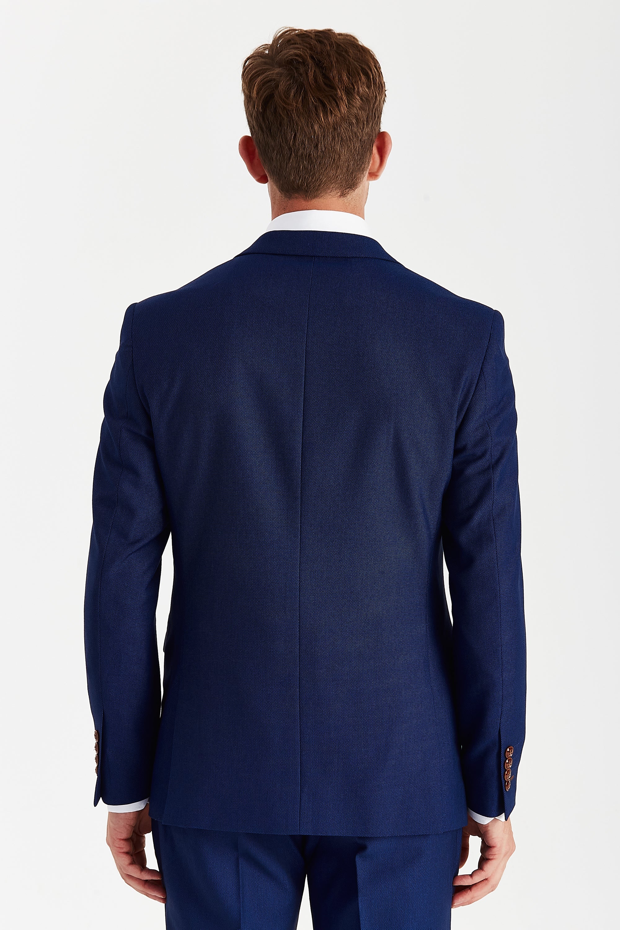 Back view of a blue textured suit jacket with matching trousers and brown sleeve buttons.