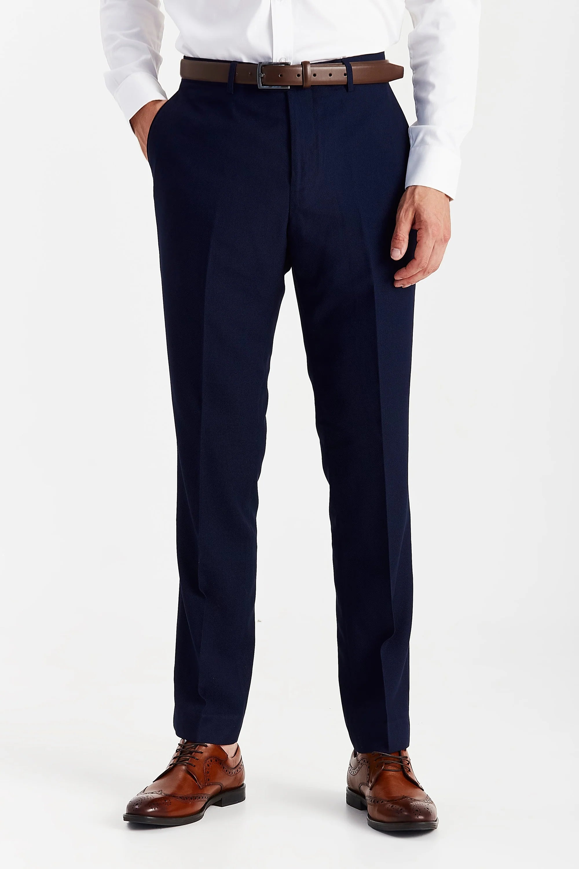 Men’s navy trousers shown from the front, worn with a white shirt and brown belt and shoes.