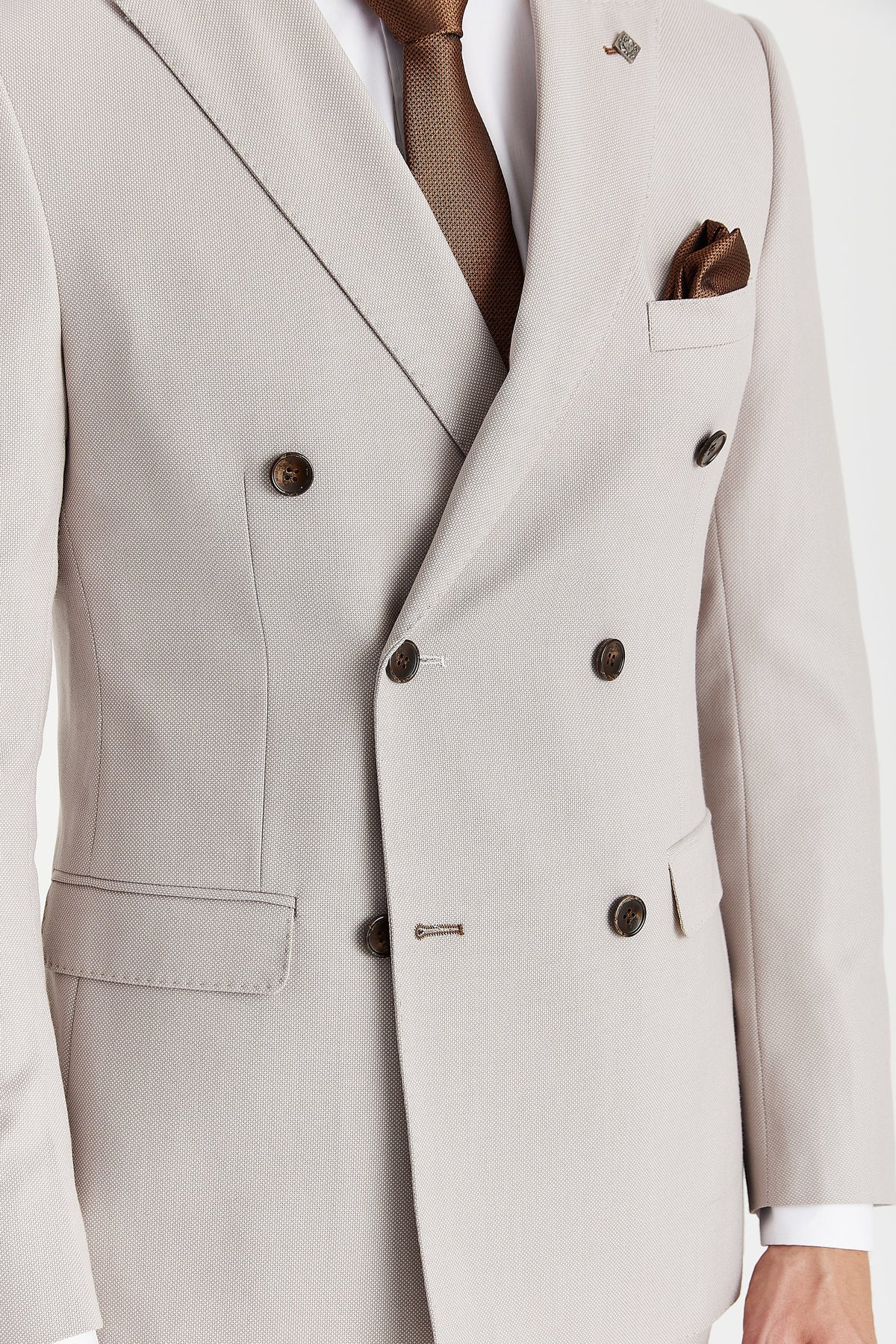 Close-up showing the stone fabric’s fine woven texture, brown buttons and contrasting brown buttonhole stitching.