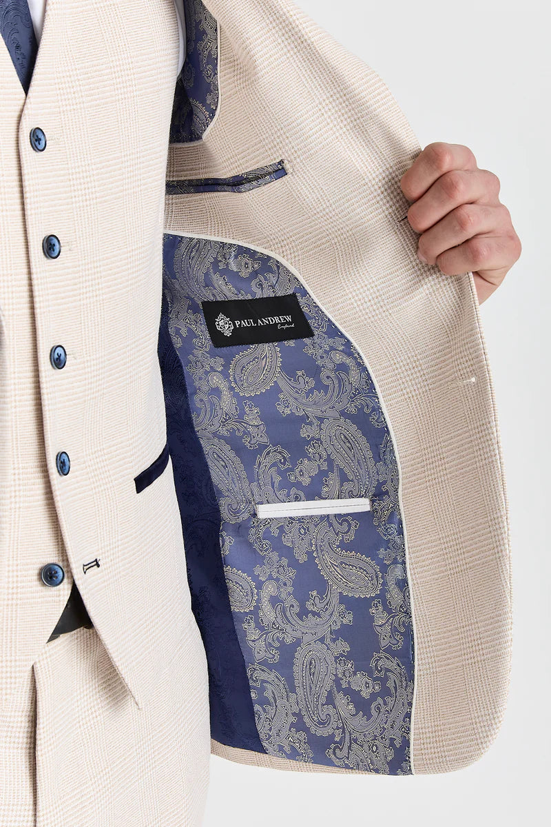 Inside view of a men's cream check suit jacket, revealing a blue and silver paisley pattern lining and a Paul Andrew brand label.
