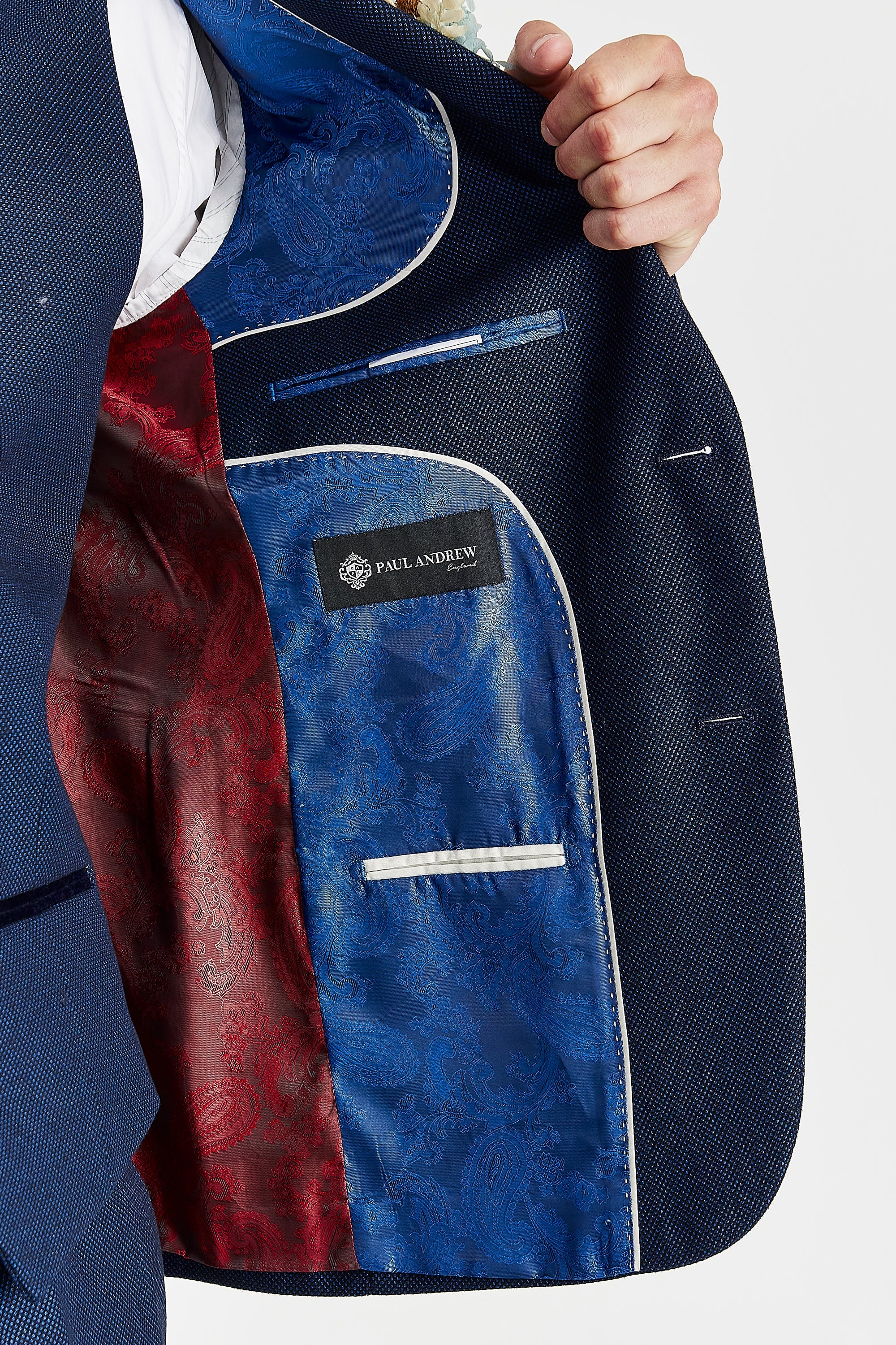 Interior view of the navy blazer with red and blue paisley lining and a visible Paul Andrew logo label.