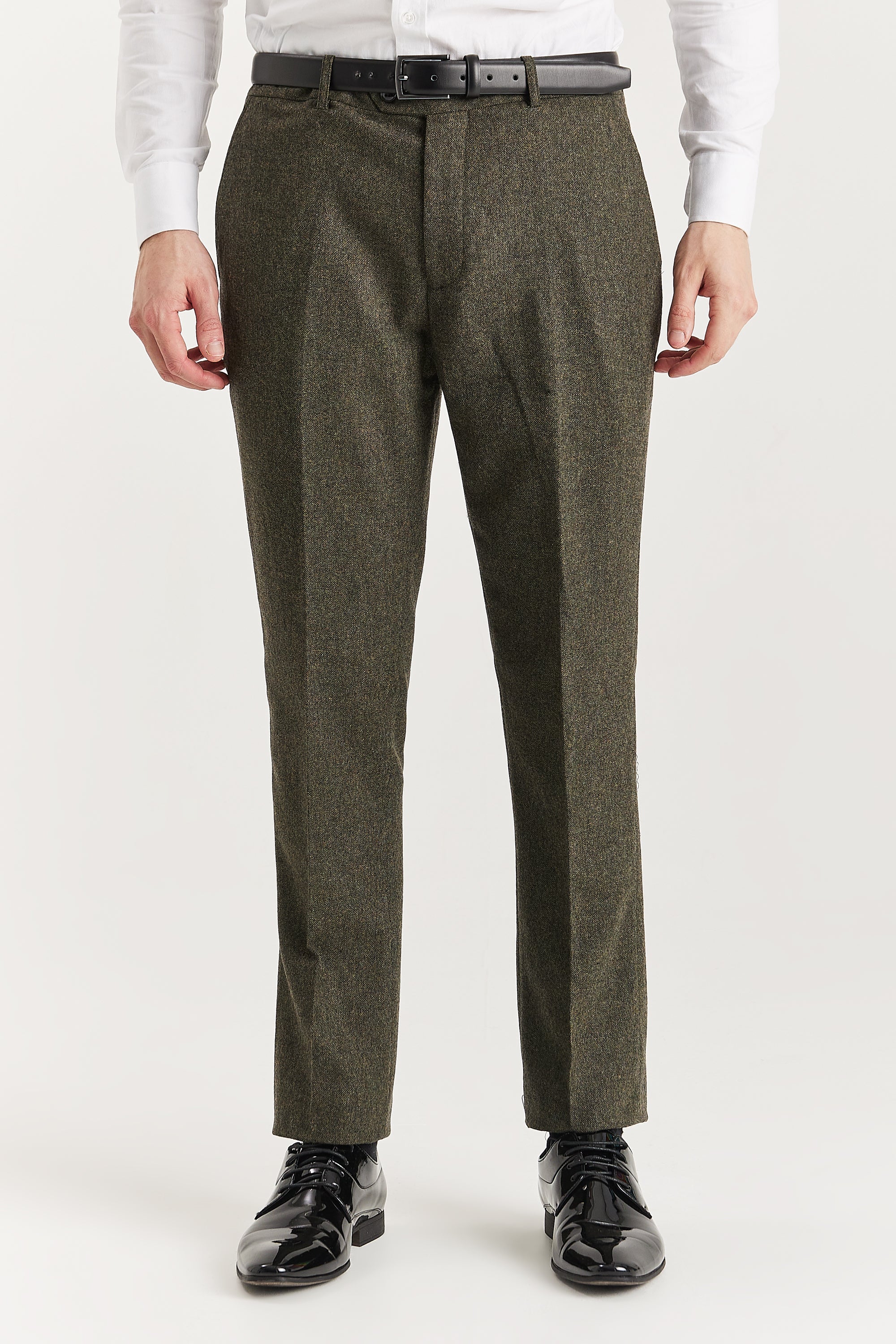 Men’s green tweed trousers shown from the front, worn with a white shirt and black belt and formal shoes.