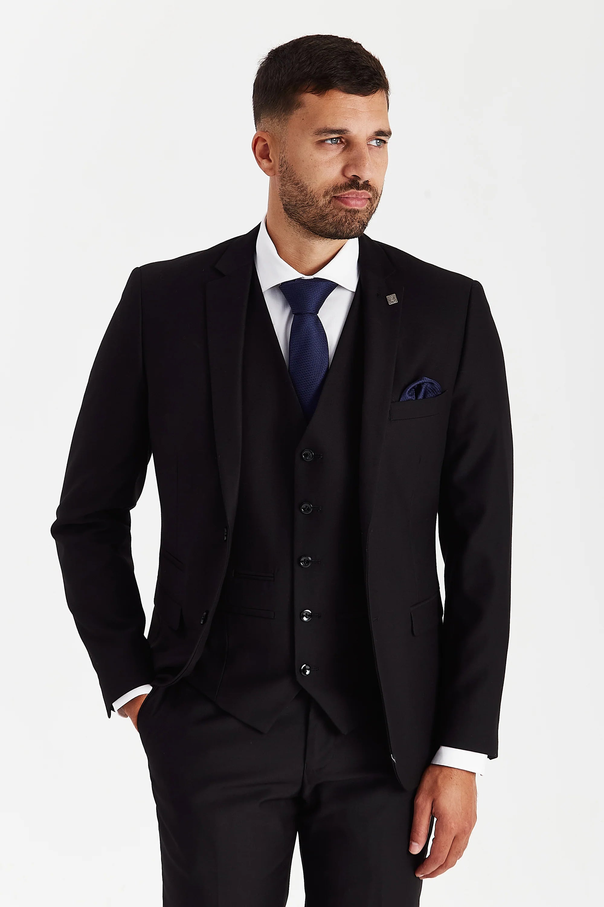 Front view of a man wearing a Parker black three piece suit with jacket, waistcoat, trousers, white shirt, navy tie and matching pocket square.