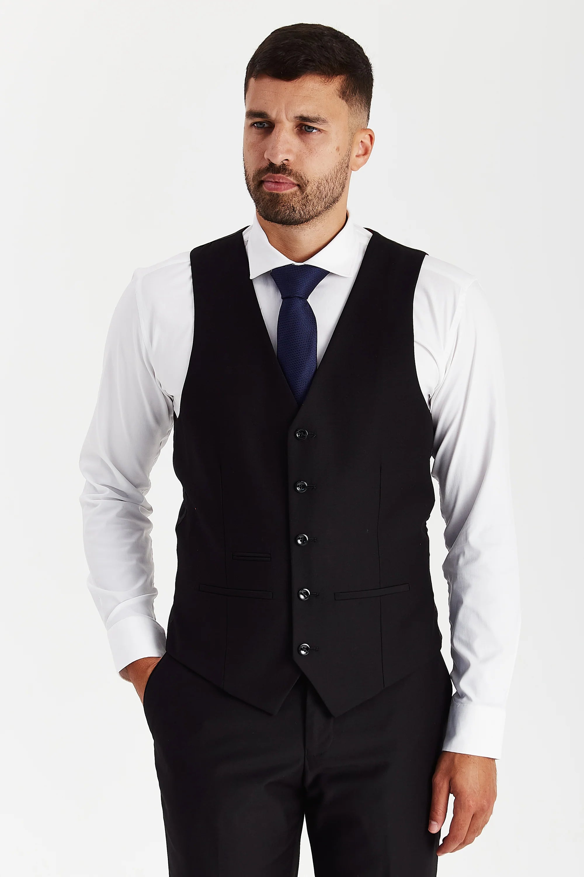 Front view of the black waistcoat, worn with black trousers, a white shirt and a navy tie.