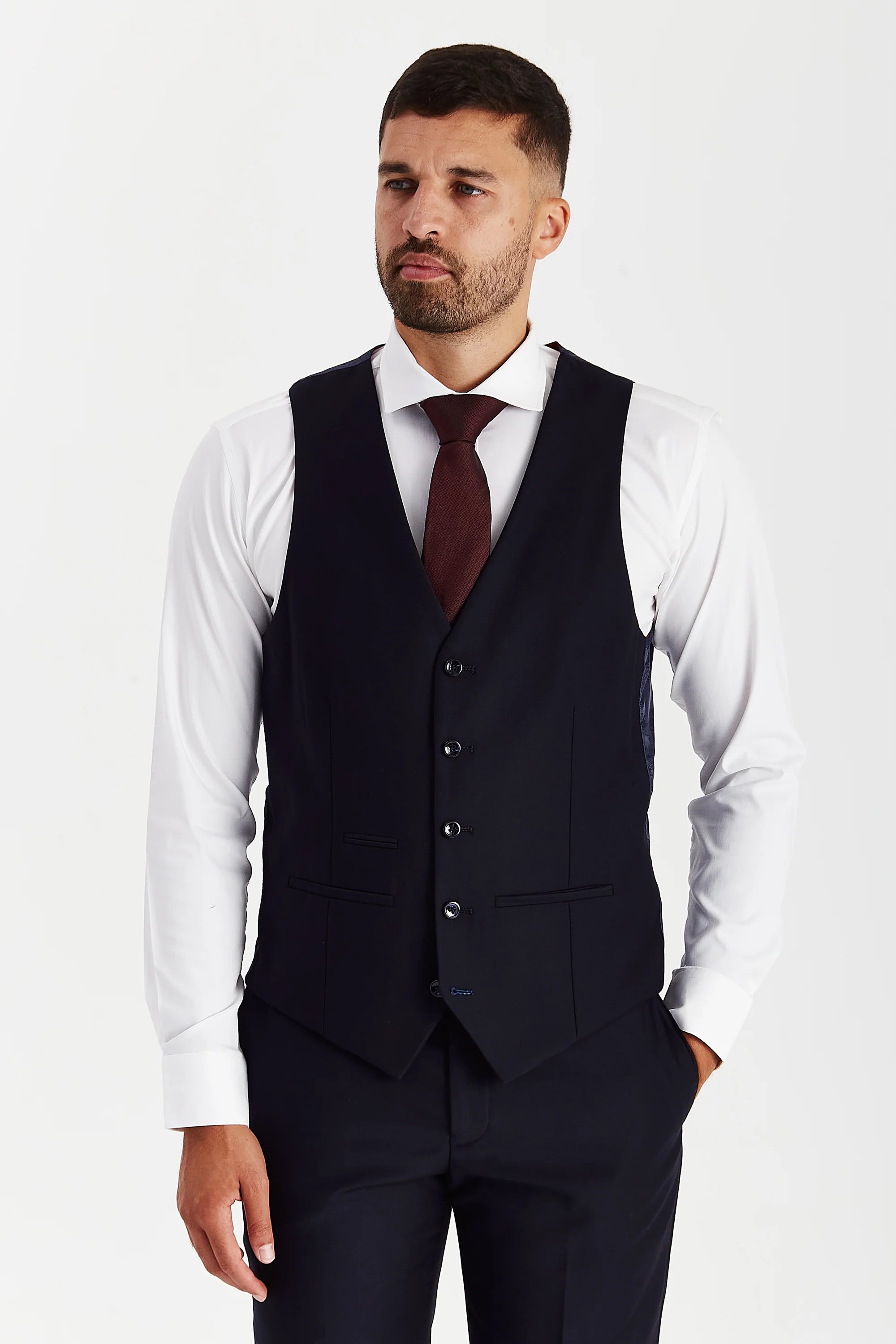 Front view of the navy waistcoat, worn with matching trousers, a white shirt and a burgundy tie.