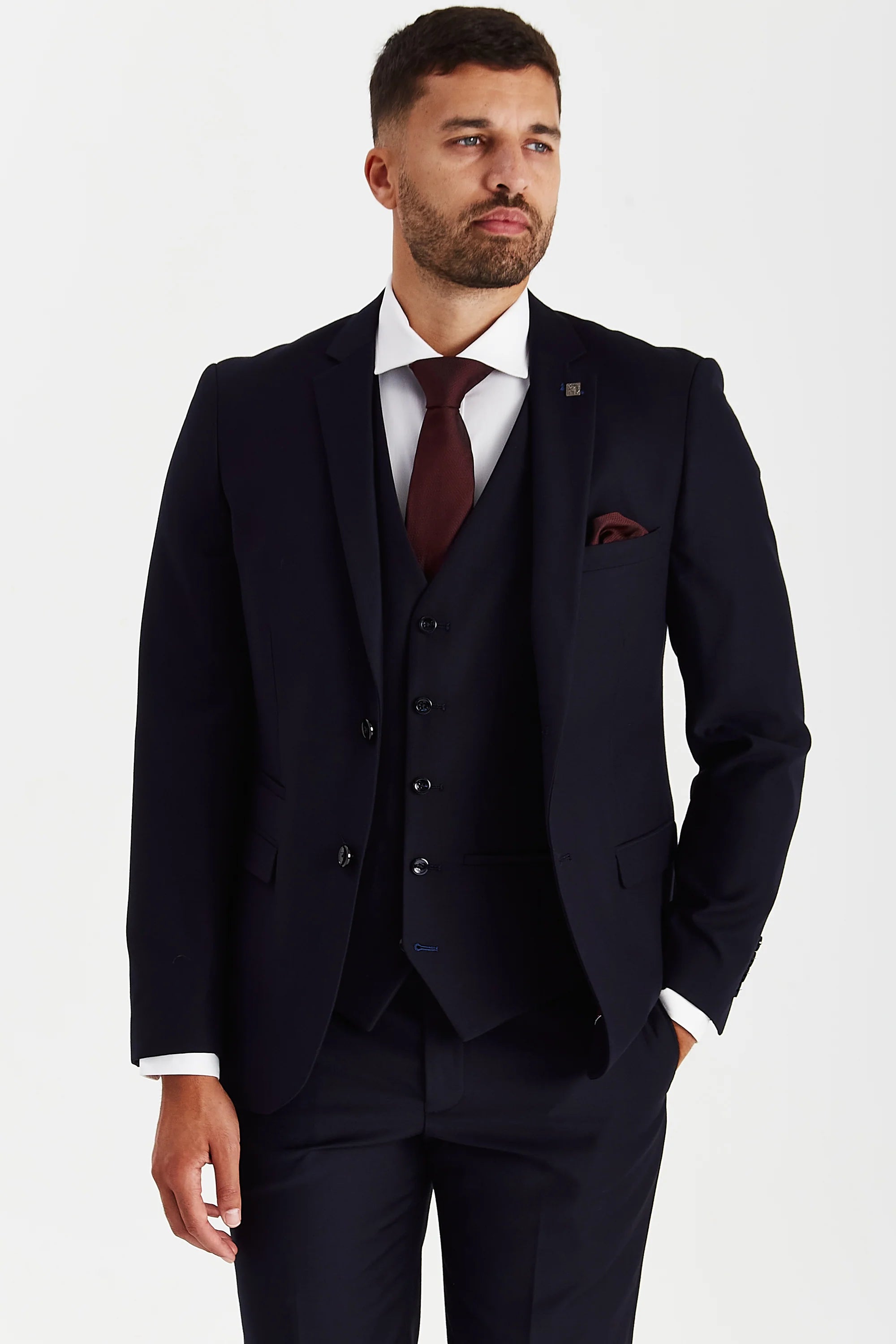 Front view of a man wearing a Parker navy three piece suit with jacket, waistcoat, trousers, white shirt, burgundy tie and matching pocket square.