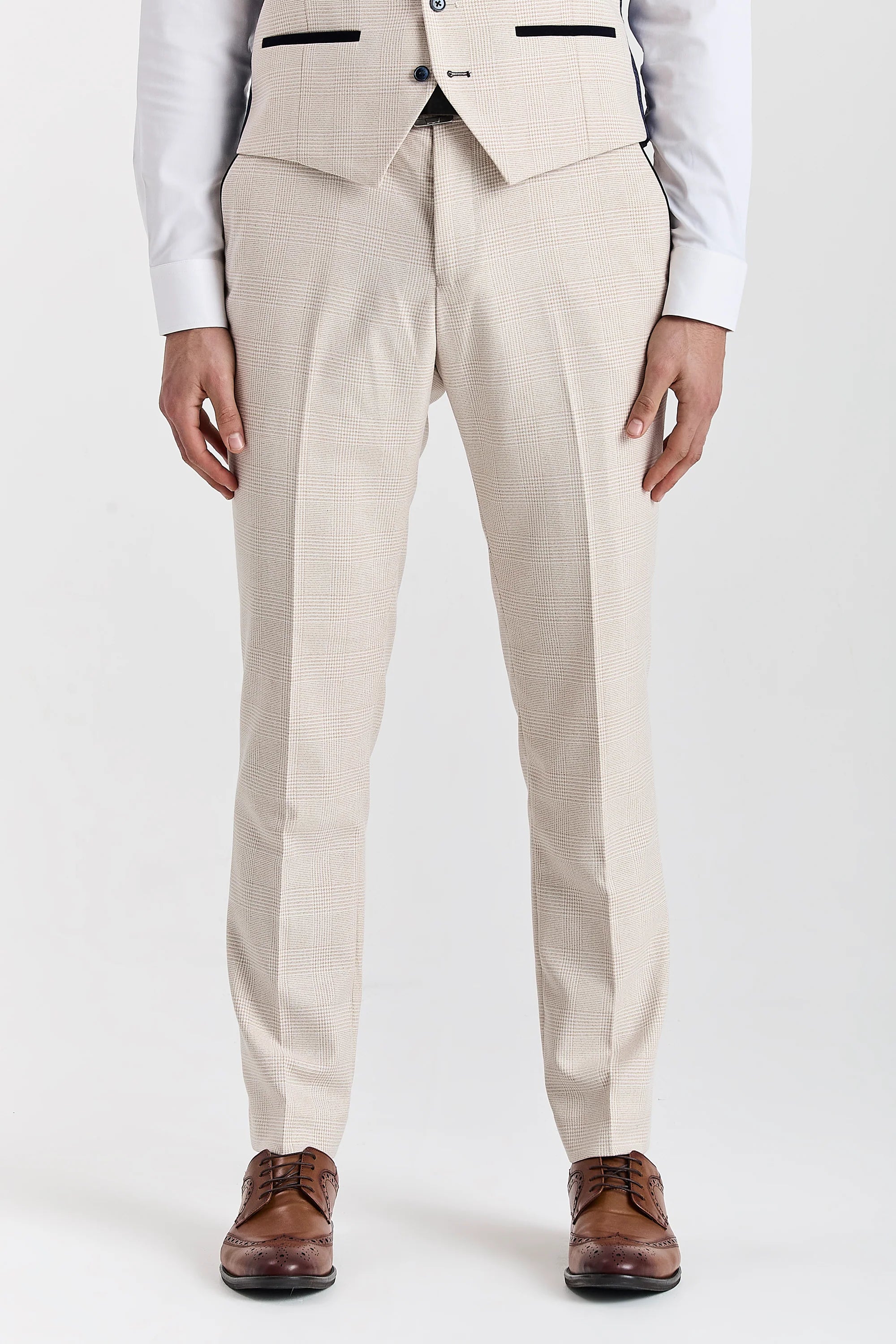 Men’s cream check trousers shown from the front, worn with the matching waistcoat, white shirt and brown brogues.