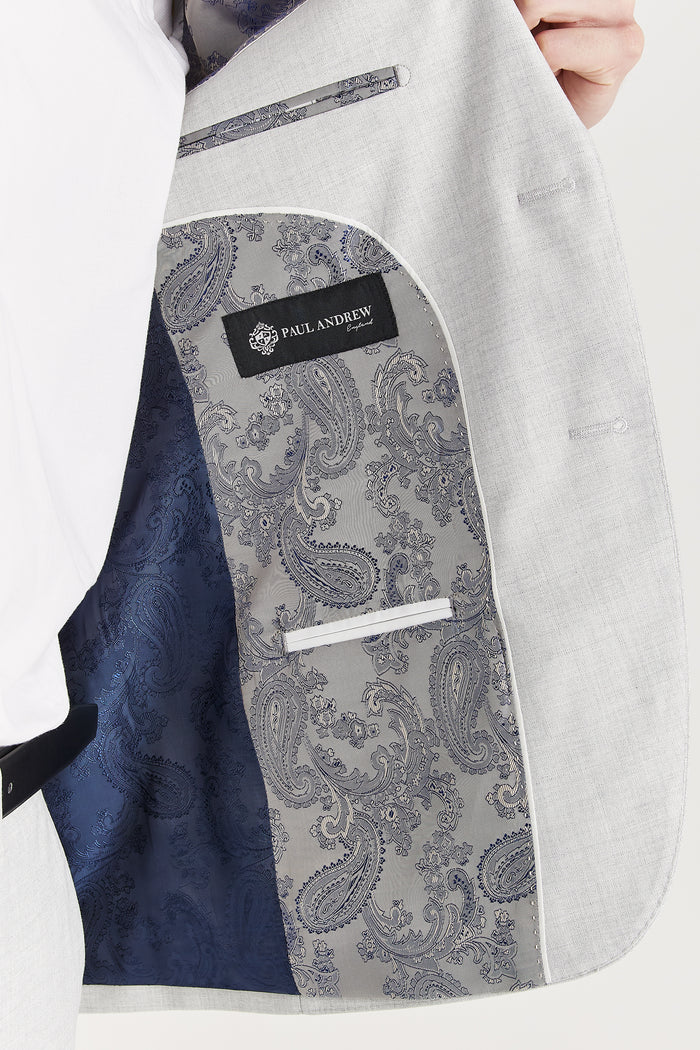 Interior view of the silver suit jacket showing intricate paisley lining and Paul Andrew branding on the inner panel.