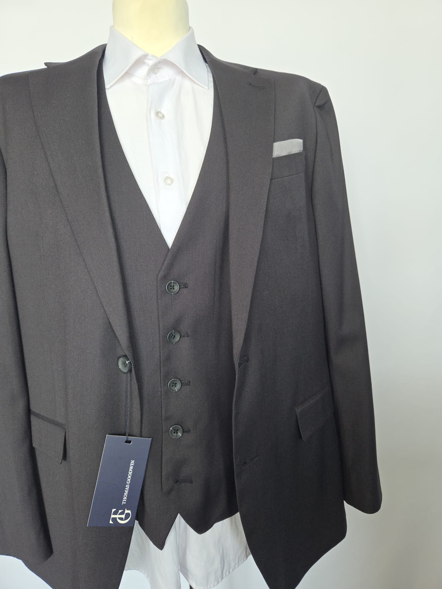 Front of black three-piece suit with jacket and matching waistcoat; flap pockets and notch lapel.